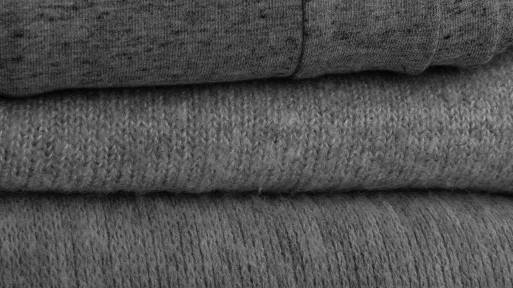 Stacked layers of folded gray Cotton-Polyester Blend fabric showing different textures.