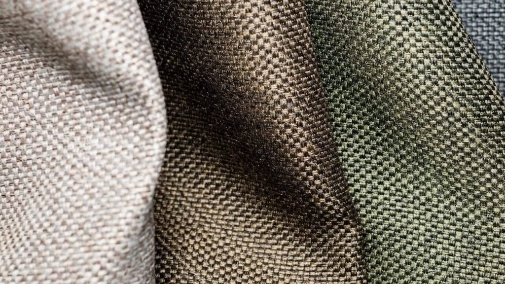 Close-up view of various textured Polyester Fabric in neutral colors.