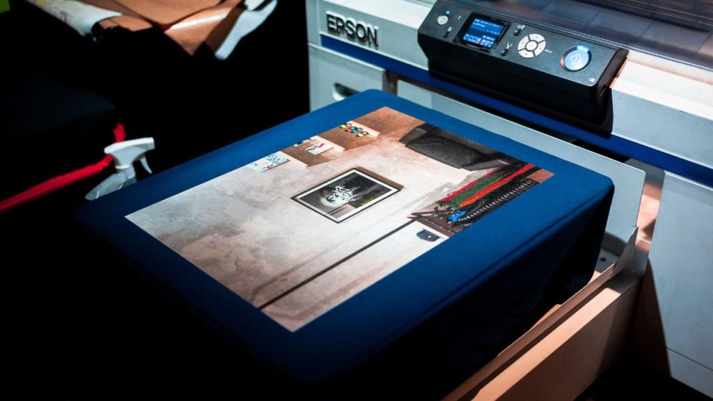 A printed Tshirt coming out of a digital printer.