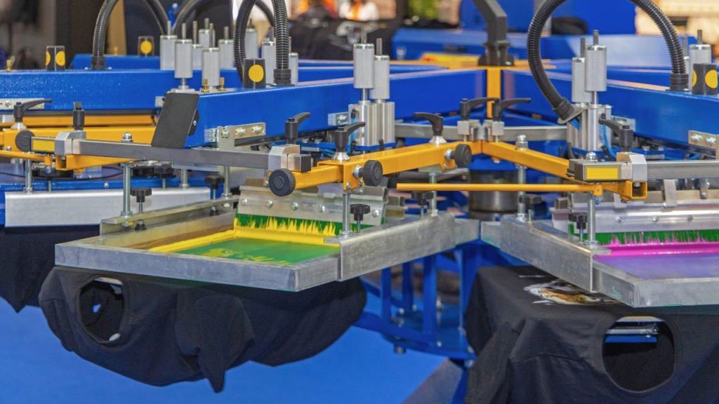 Multiple automated machines performing screen printing.